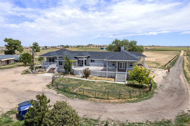 rear view of house featuring a rural view and a porch