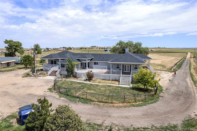 view of front of house with stairs, driveway, a porch, and a fenced front yard