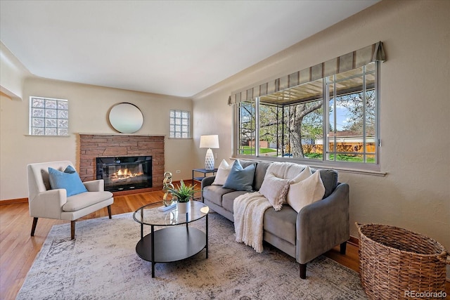 living area featuring baseboards, a fireplace, and wood finished floors