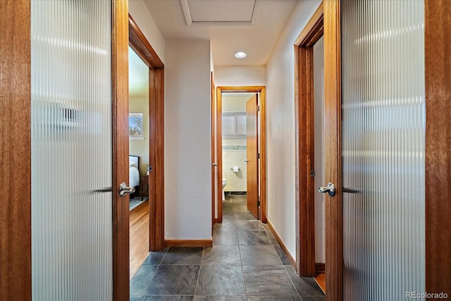 corridor featuring baseboards and stone finish flooring