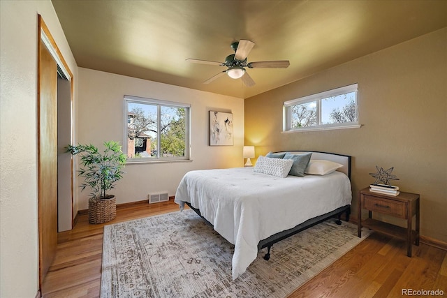 bedroom with light wood-style floors, baseboards, and visible vents