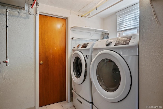 washroom featuring light tile patterned floors, laundry area, and washing machine and clothes dryer