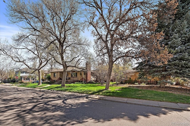 view of front facade with a chimney and a front lawn