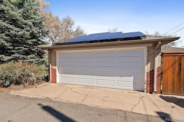 detached garage featuring roof mounted solar panels