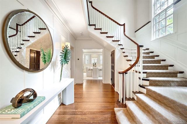 entrance foyer featuring crown molding, dark hardwood / wood-style floors, and a high ceiling