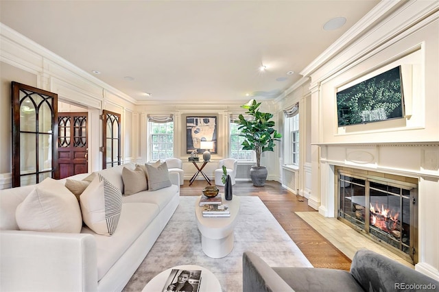 living room featuring light hardwood / wood-style flooring and ornamental molding