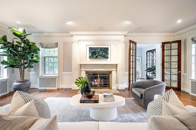 living room with ornamental molding, radiator, and wood-type flooring