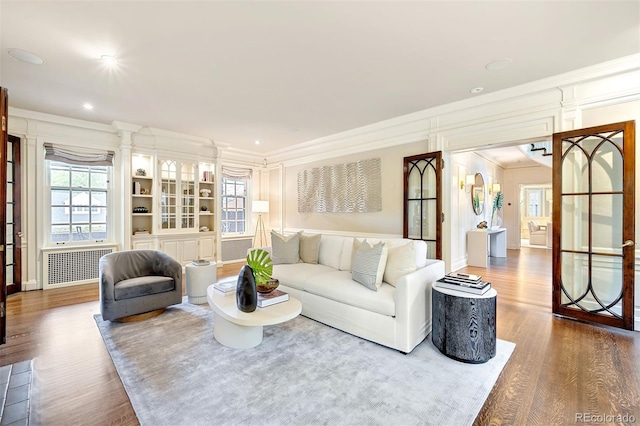 living room with ornamental molding, radiator, and hardwood / wood-style floors