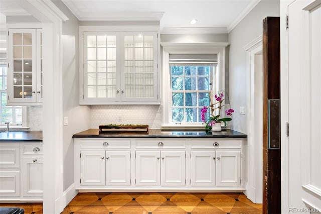 bar with white cabinetry, crown molding, and tasteful backsplash