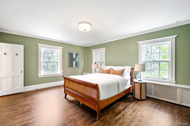 bedroom with multiple windows, ornamental molding, radiator, and dark wood-type flooring