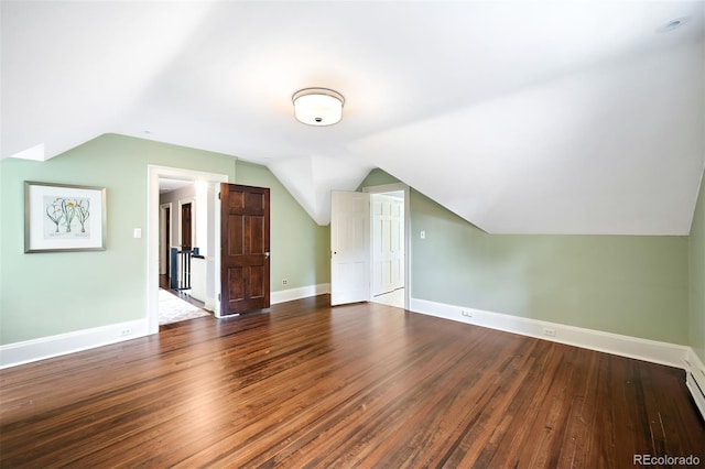 additional living space featuring wood-type flooring and vaulted ceiling