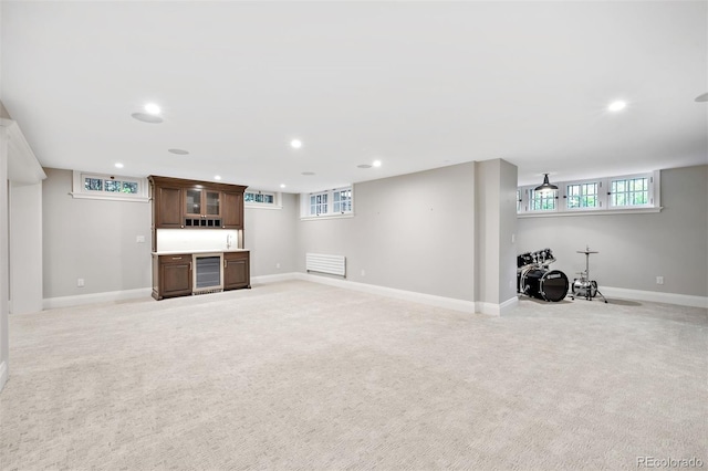 basement with plenty of natural light, light carpet, and wine cooler