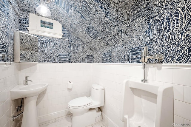 bathroom featuring tile patterned flooring, tile walls, and toilet