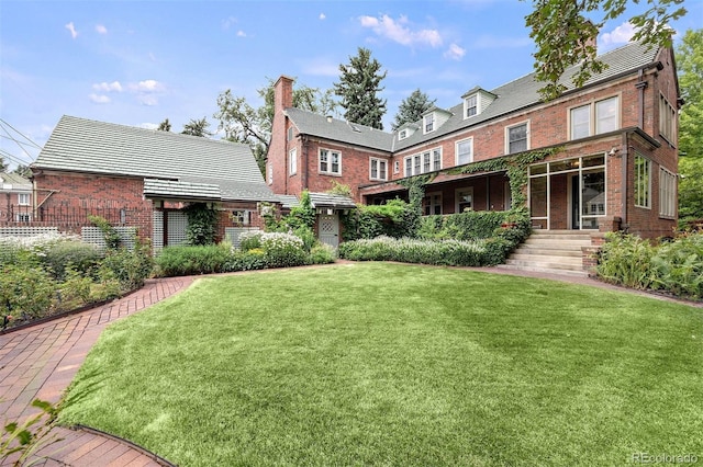 rear view of house featuring a lawn