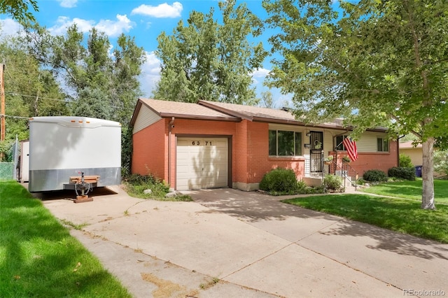 6371 Brooks Dr, Arvada, CO 80004 - view of front of home featuring a garage, a front yard, brick siding, and concrete driveway