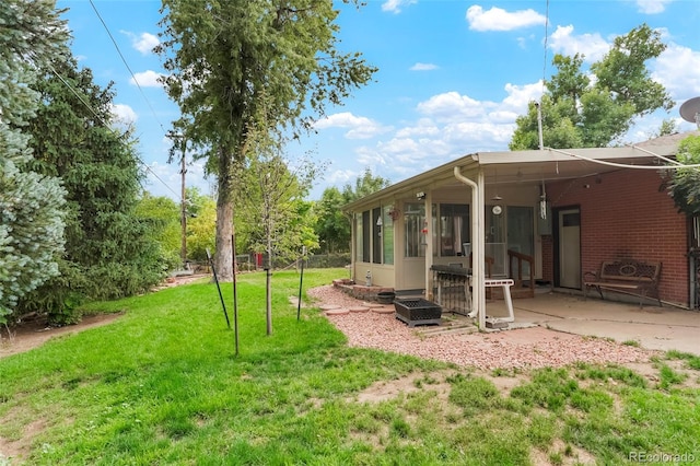 6371 Brooks Dr, Arvada, CO 80004 - view of grassy yard featuring a sunroom and a patio