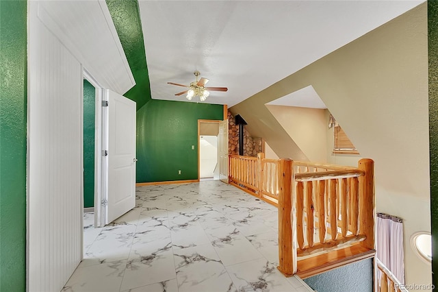 bonus room featuring a ceiling fan, marble finish floor, vaulted ceiling, and baseboards