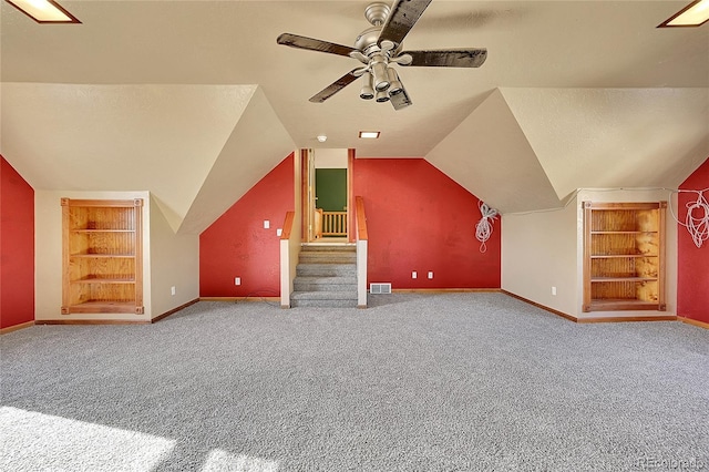 additional living space with a textured ceiling, baseboards, visible vents, and built in features