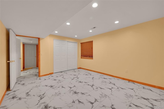 unfurnished bedroom featuring marble finish floor, a closet, recessed lighting, and baseboards