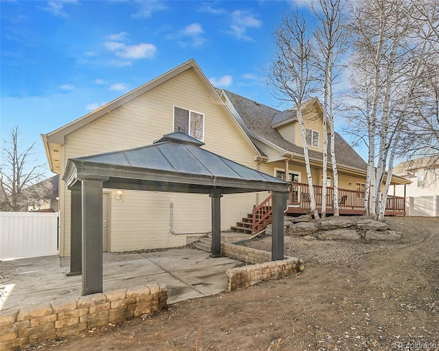 rear view of house featuring a gazebo, a patio area, fence, and a wooden deck