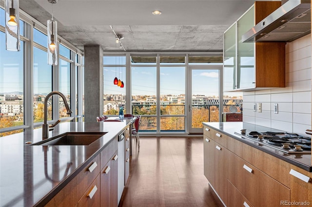 kitchen featuring sink, stainless steel gas cooktop, backsplash, pendant lighting, and extractor fan