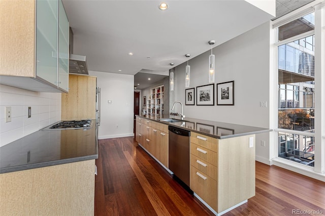 kitchen with a kitchen island with sink, dark hardwood / wood-style flooring, sink, and appliances with stainless steel finishes