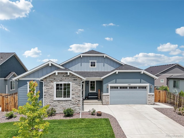 15987 E 115th Pl, Commerce City, CO 80022 - craftsman-style home featuring board and batten siding, stone siding, an attached garage, and driveway