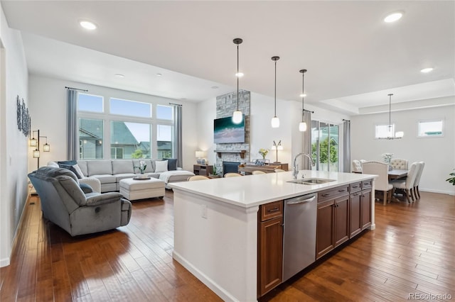 15987 E 115th Pl, Commerce City, CO 80022 - kitchen with dishwasher, open floor plan, a sink, a fireplace, and dark wood-style floors