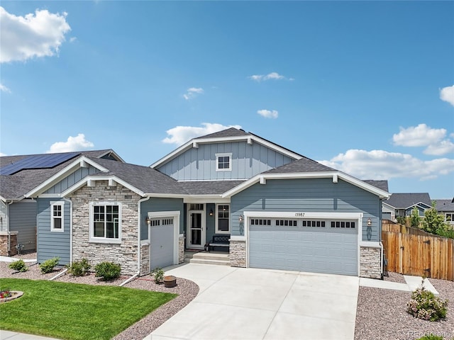 15987 E 115th Pl, Commerce City, CO 80022 - craftsman-style home with board and batten siding, a garage, stone siding, driveway, and roof with shingles