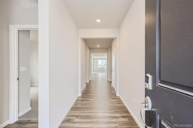 corridor with light hardwood / wood-style floors