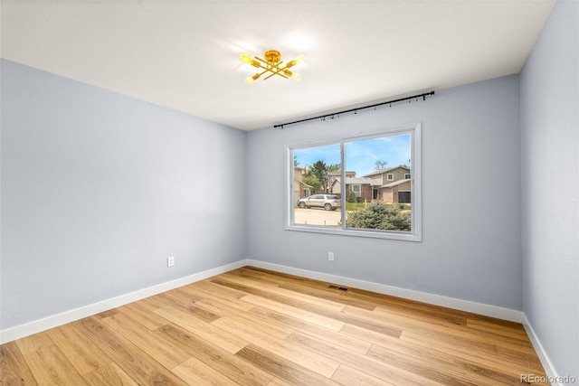 spare room featuring light wood-style flooring and baseboards