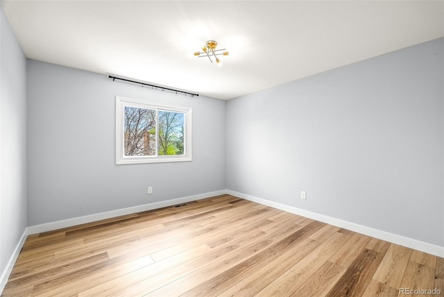 unfurnished room featuring light wood finished floors and baseboards