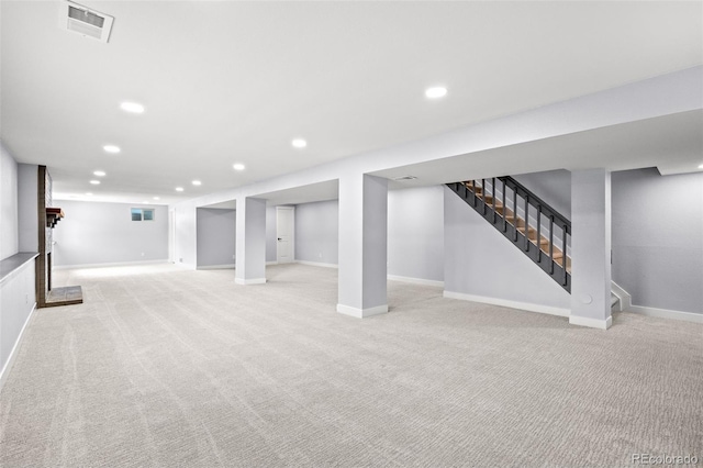 finished basement featuring baseboards, recessed lighting, visible vents, and light colored carpet