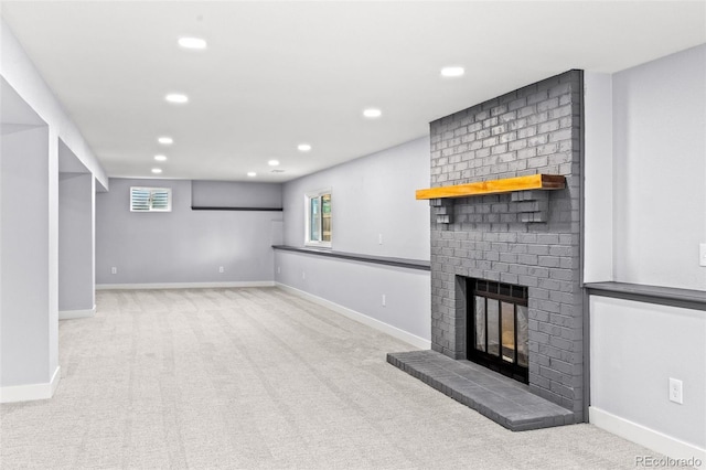 unfurnished living room featuring a fireplace, carpet flooring, baseboards, and recessed lighting