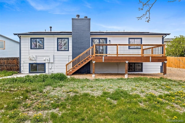 back of house with solar panels, stairway, fence, and a wooden deck