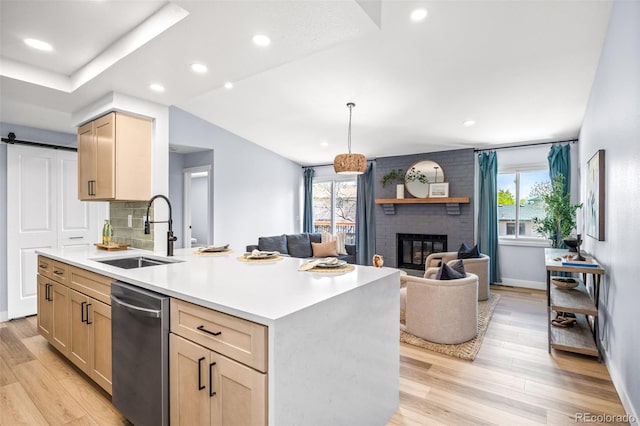 kitchen featuring a sink, dishwasher, healthy amount of natural light, light wood finished floors, and recessed lighting