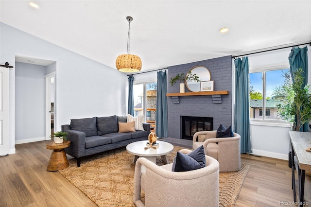living room featuring plenty of natural light, baseboards, a brick fireplace, light wood finished floors, and recessed lighting
