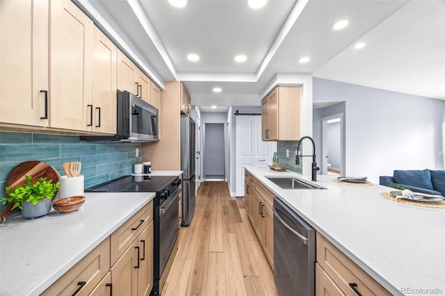 kitchen with appliances with stainless steel finishes, a sink, light wood-style floors, recessed lighting, and light brown cabinets