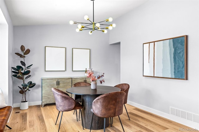 dining area with a chandelier, baseboards, and wood finished floors