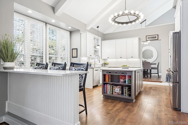 kitchen with hanging light fixtures, white cabinets, and stainless steel appliances