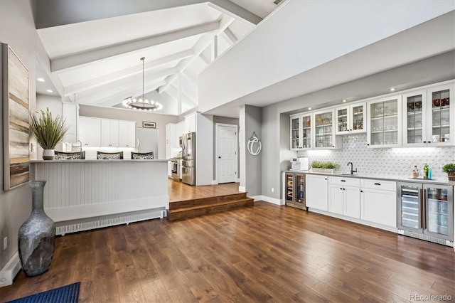 kitchen with backsplash, wine cooler, white cabinets, and high vaulted ceiling