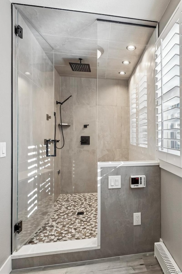 bathroom with a tile shower and hardwood / wood-style flooring