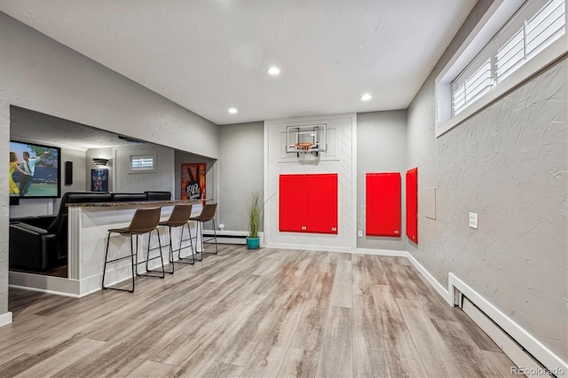 interior space featuring a baseboard heating unit and wood-type flooring