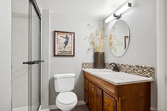 full bath with backsplash, toilet, vanity, tiled shower, and baseboards