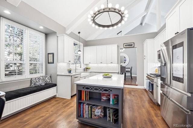 kitchen featuring stainless steel appliances, tasteful backsplash, light countertops, lofted ceiling with beams, and a kitchen island