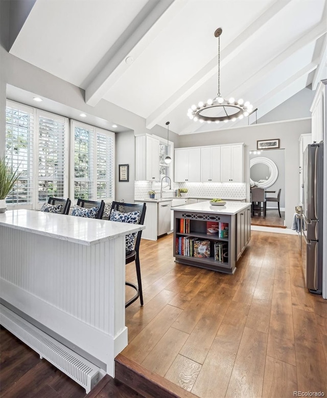 kitchen featuring tasteful backsplash, appliances with stainless steel finishes, vaulted ceiling with beams, light countertops, and open shelves