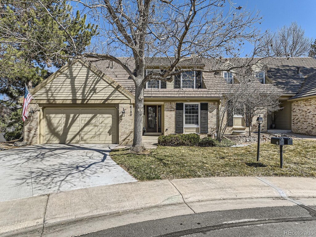 view of front of house with a garage, brick siding, and concrete driveway