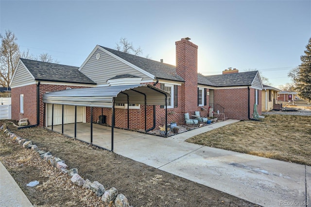 back of house with a garage and a carport