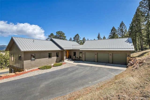 96 Garnet Ln, Pine, CO 80470 - view of front of house with a garage, a metal roof, and driveway
