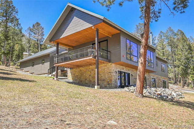 96 Garnet Ln, Pine, CO 80470 - back of house featuring stone siding, a lawn, and a balcony